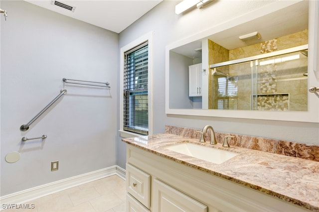 bathroom featuring tile patterned flooring, vanity, and an enclosed shower