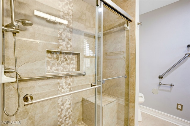 bathroom with tile patterned flooring, toilet, and walk in shower