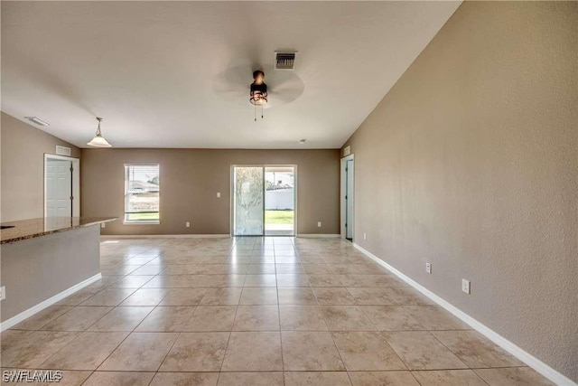 tiled spare room with ceiling fan