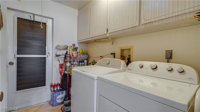 laundry area featuring cabinets, washer and clothes dryer, and light tile patterned floors