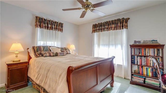 bedroom with multiple windows, light carpet, and ceiling fan