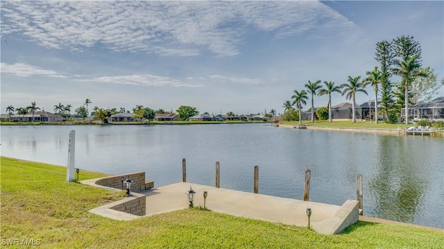 view of dock with a water view and a lawn