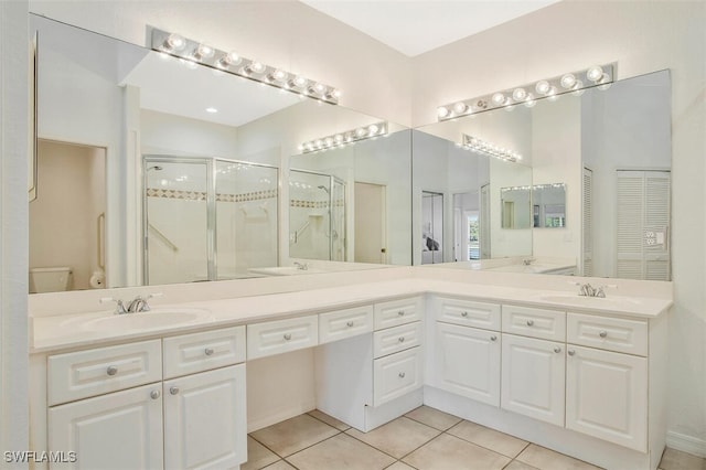 bathroom with vanity, toilet, tile patterned floors, and walk in shower