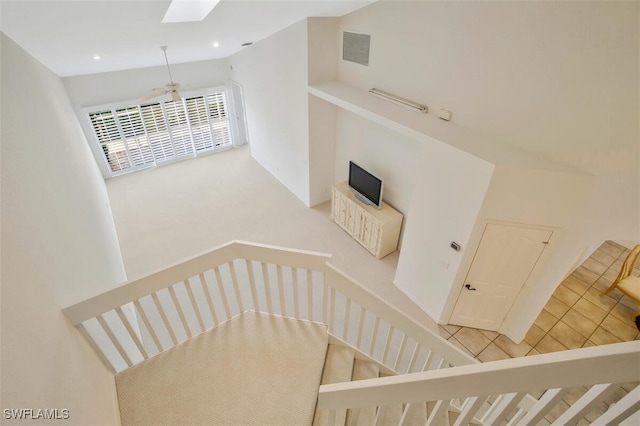 staircase with a skylight and carpet