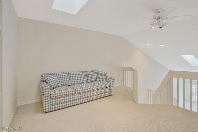 sitting room with lofted ceiling with skylight, carpet, and ceiling fan