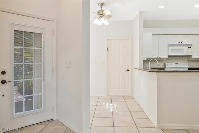 kitchen featuring light tile patterned floors, white appliances, sink, ceiling fan, and white cabinets