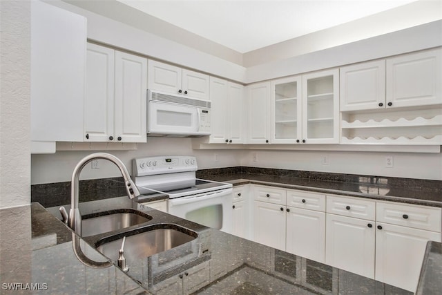 kitchen featuring dark stone countertops, white appliances, and white cabinets