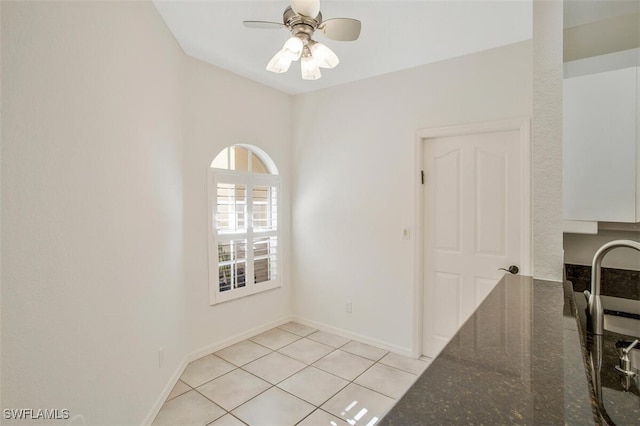 empty room featuring ceiling fan and light tile patterned flooring