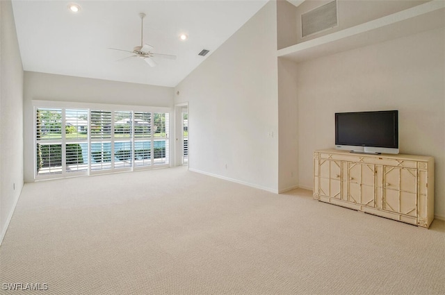 unfurnished living room with ceiling fan, light colored carpet, and high vaulted ceiling