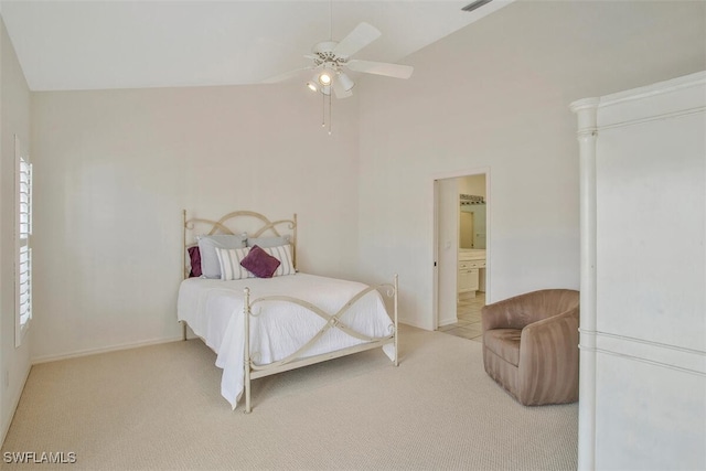 bedroom featuring light carpet, lofted ceiling, ceiling fan, and ensuite bathroom