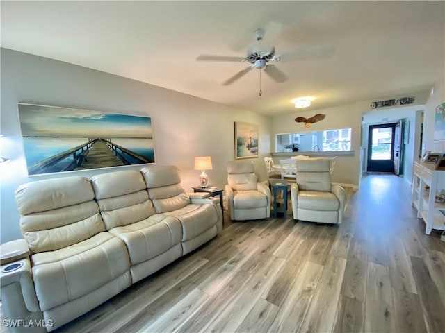 living room featuring ceiling fan and light hardwood / wood-style floors