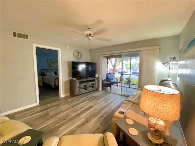 living room featuring ceiling fan and wood-type flooring