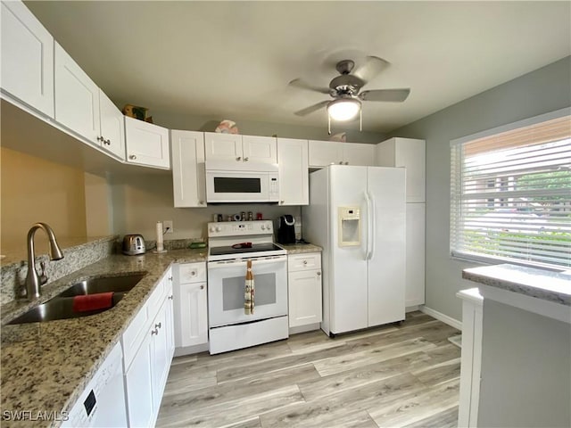 kitchen featuring sink, white cabinets, light stone counters, white appliances, and light hardwood / wood-style flooring