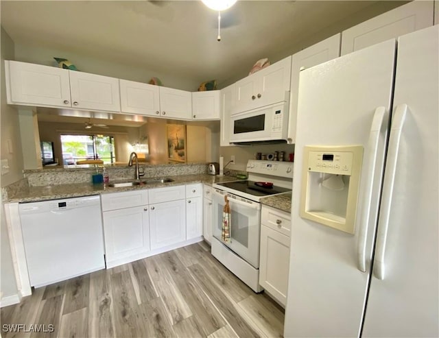 kitchen featuring white cabinetry, white appliances, sink, and light stone counters