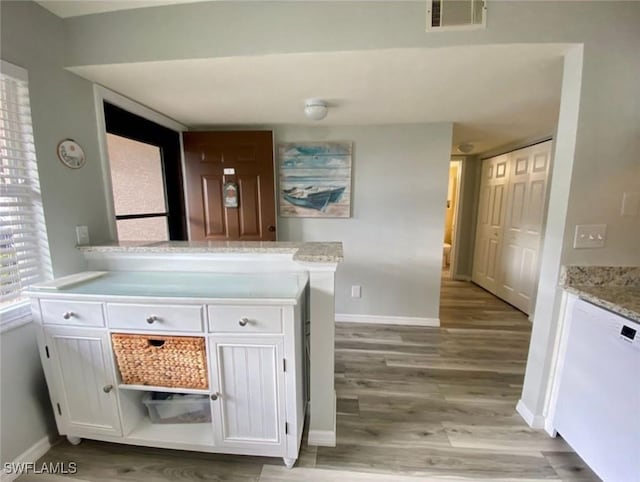 kitchen featuring light stone counters, light hardwood / wood-style flooring, white dishwasher, kitchen peninsula, and white cabinets