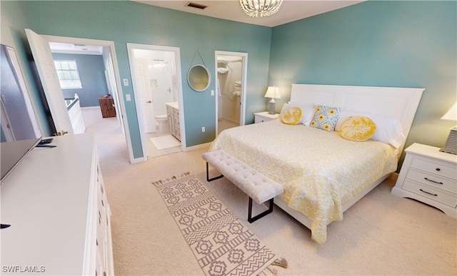 bedroom with connected bathroom and light colored carpet