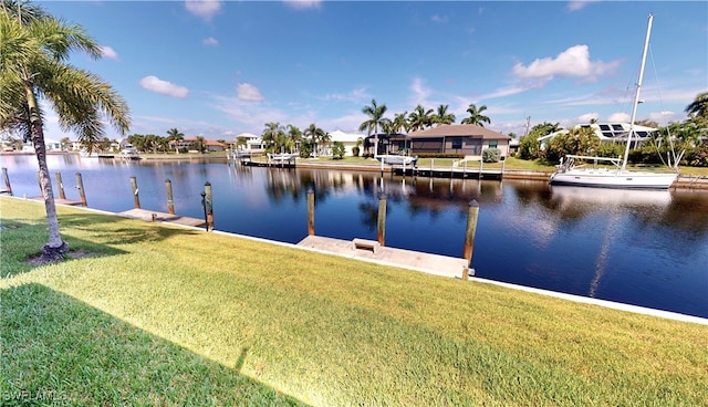 view of dock with a lawn and a water view