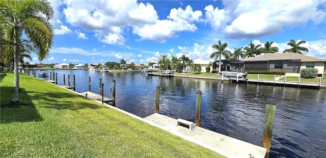 view of dock featuring a lawn and a water view