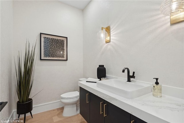 bathroom with vanity, wood-type flooring, and toilet