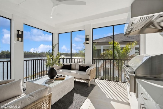 sunroom / solarium with ceiling fan and a water view