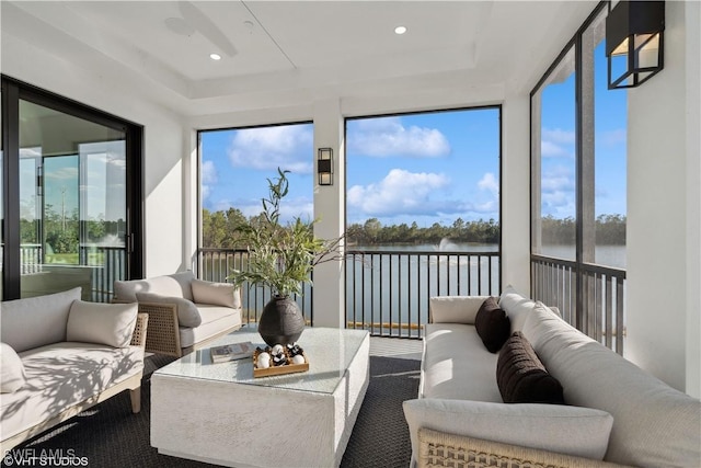 sunroom featuring a water view