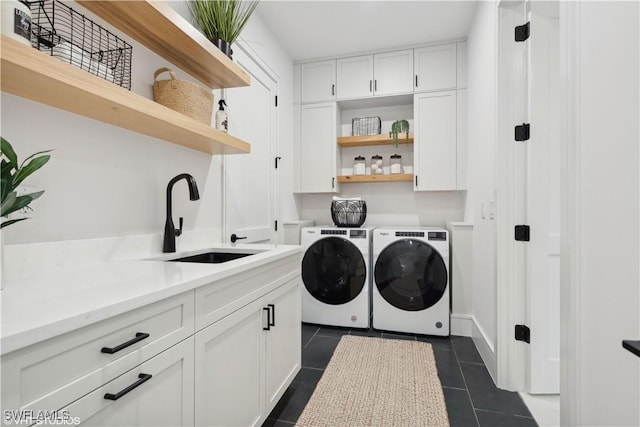 washroom featuring dark tile patterned flooring, cabinets, independent washer and dryer, and sink