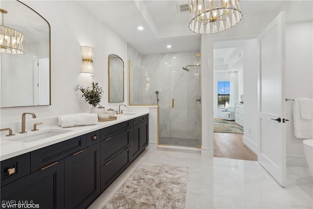 bathroom with a notable chandelier, a shower with door, and vanity