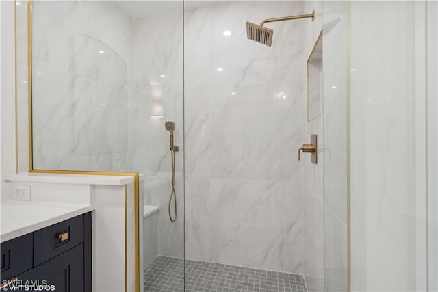 bathroom featuring a tile shower and vanity