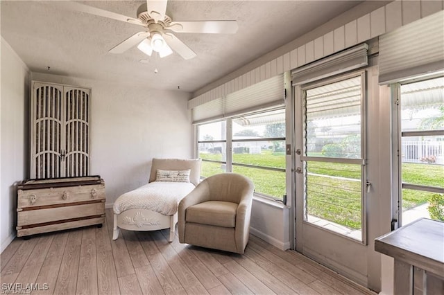 living area featuring light hardwood / wood-style flooring and ceiling fan