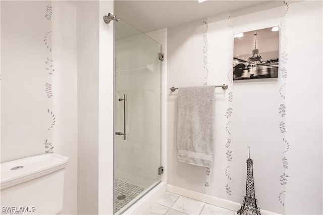 bathroom featuring tile patterned flooring, toilet, and a shower with door