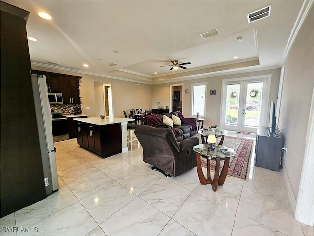 living room with french doors, a raised ceiling, ceiling fan, and crown molding