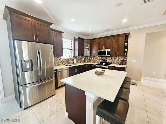 kitchen featuring a center island, a kitchen breakfast bar, sink, dark brown cabinetry, and stainless steel appliances