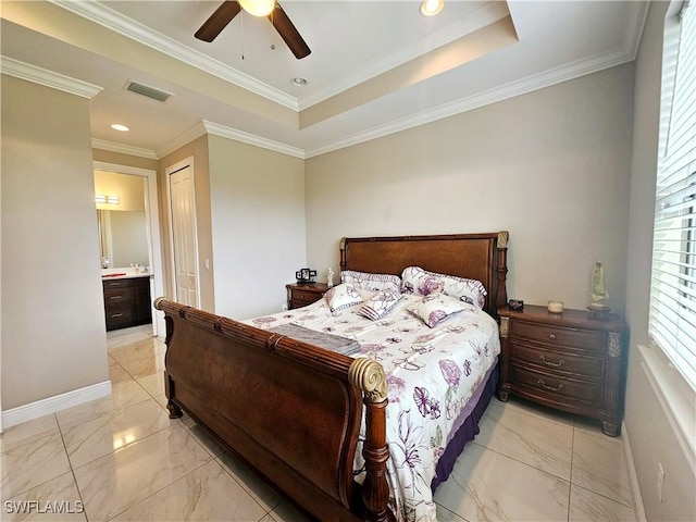 bedroom featuring ceiling fan, a raised ceiling, ornamental molding, and ensuite bath