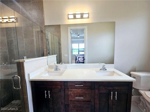 bathroom featuring ceiling fan, vanity, an enclosed shower, and toilet