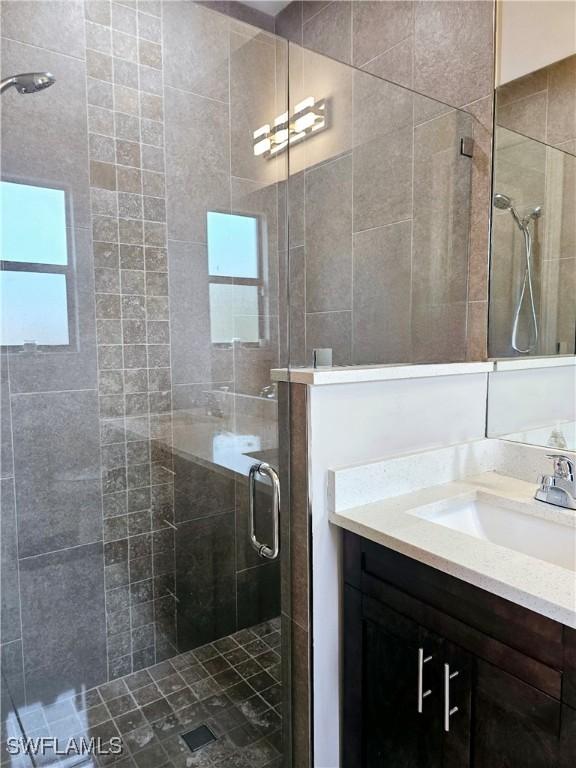 bathroom featuring vanity and a shower with door