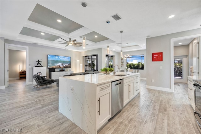 kitchen with pendant lighting, white cabinets, ceiling fan with notable chandelier, a spacious island, and appliances with stainless steel finishes