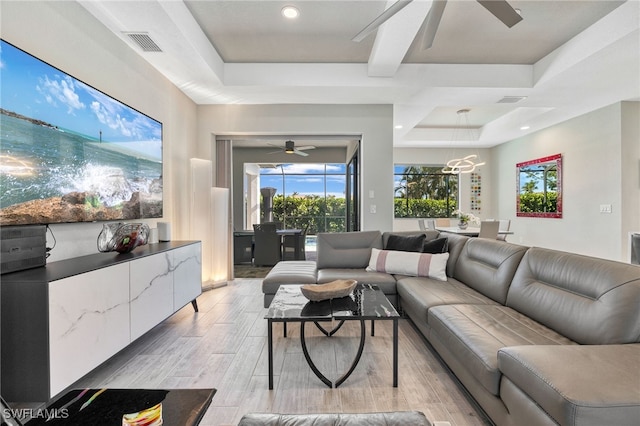 living room with ceiling fan and a tray ceiling