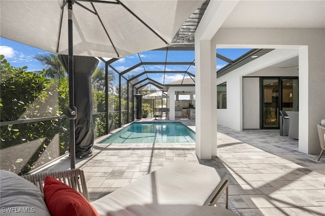 view of pool with glass enclosure and a patio area