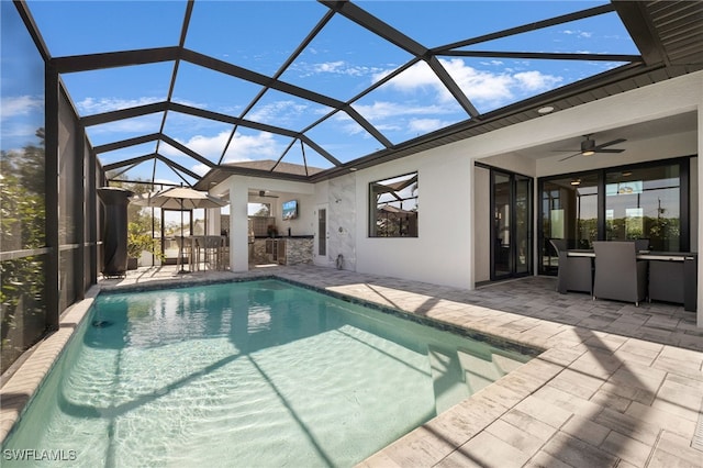 view of swimming pool with a patio area, ceiling fan, a bar, and glass enclosure