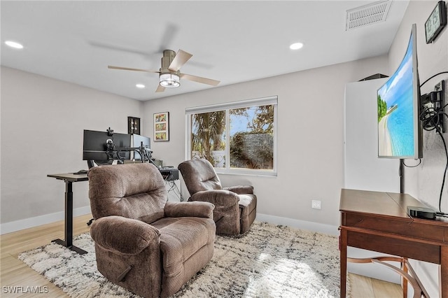 living area with ceiling fan and light hardwood / wood-style flooring