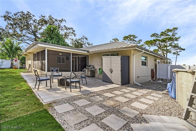 back of house featuring a sunroom, a patio area, and a yard