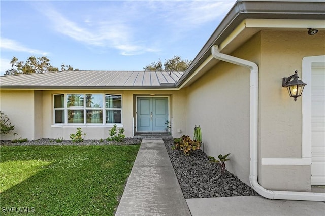 view of exterior entry with a yard