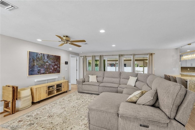 living room with ceiling fan and light wood-type flooring