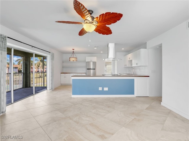 kitchen featuring island exhaust hood, stainless steel fridge, decorative light fixtures, decorative backsplash, and white cabinets