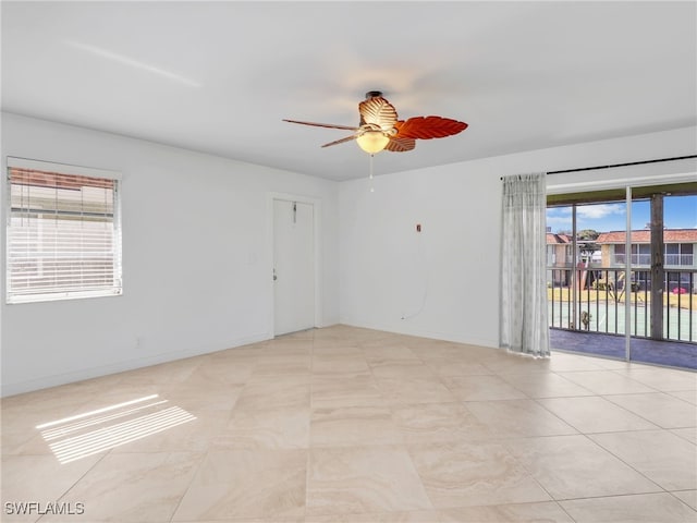 tiled spare room featuring plenty of natural light and ceiling fan