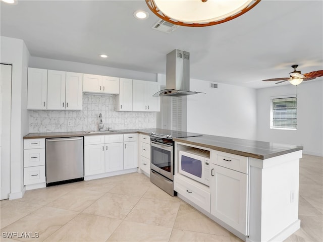 kitchen with white cabinetry, kitchen peninsula, stainless steel appliances, and extractor fan