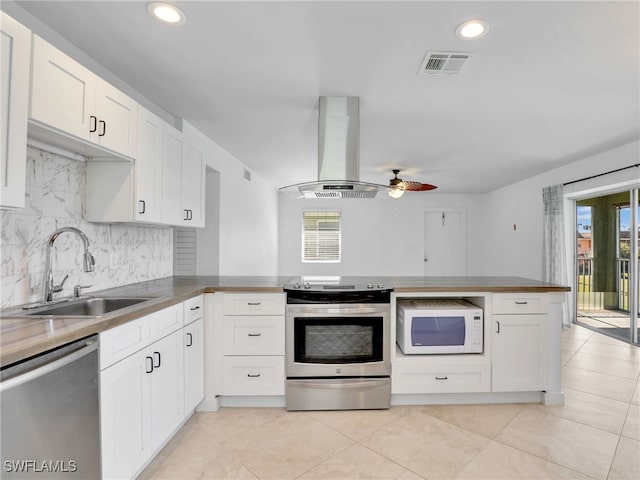 kitchen with white cabinetry, sink, kitchen peninsula, island range hood, and appliances with stainless steel finishes