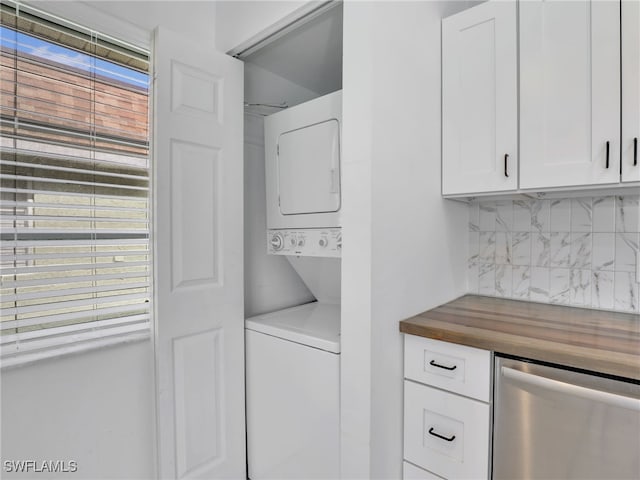 washroom featuring stacked washer and clothes dryer