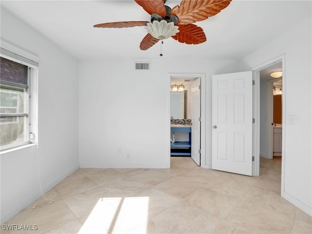 unfurnished bedroom featuring ceiling fan and ensuite bath