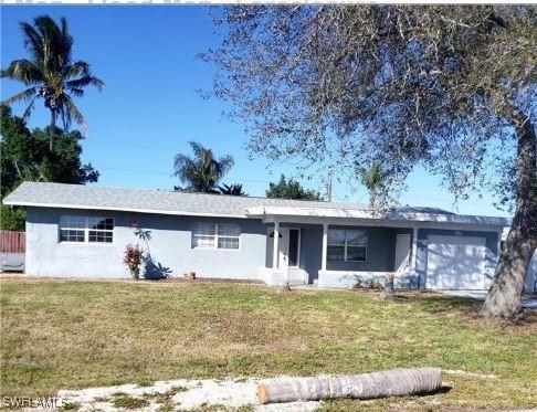 ranch-style house with a front yard and a garage